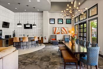 A modern dining room with a long table and chairs.
